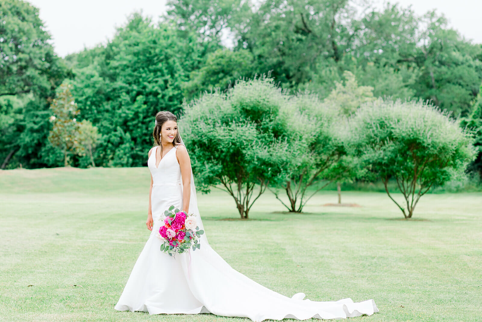 Bride holding Pink bouquet in a Trumpet Wedding Dress photo by Kimberly Harrell Photography