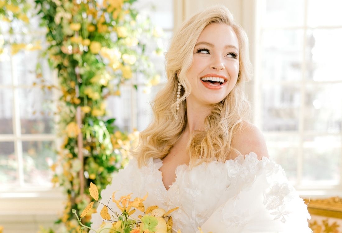 Bride in a white Ball gown dress with Yellow bouquet and Arch