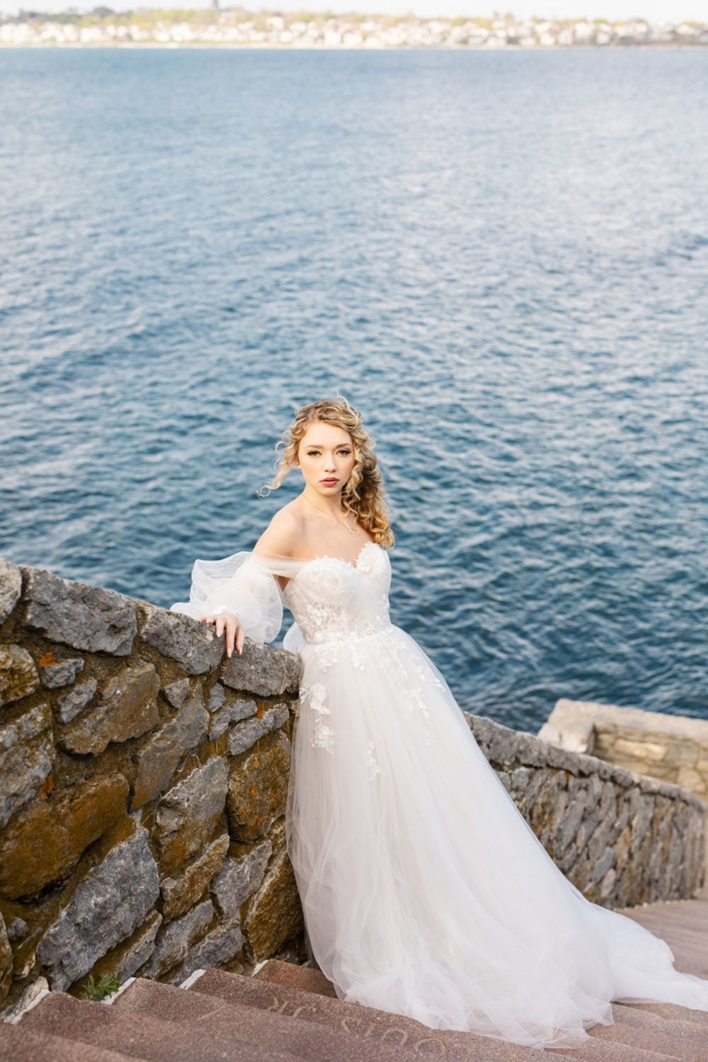 Bride standing outdoor by the lake in a white A-Line wedding gown