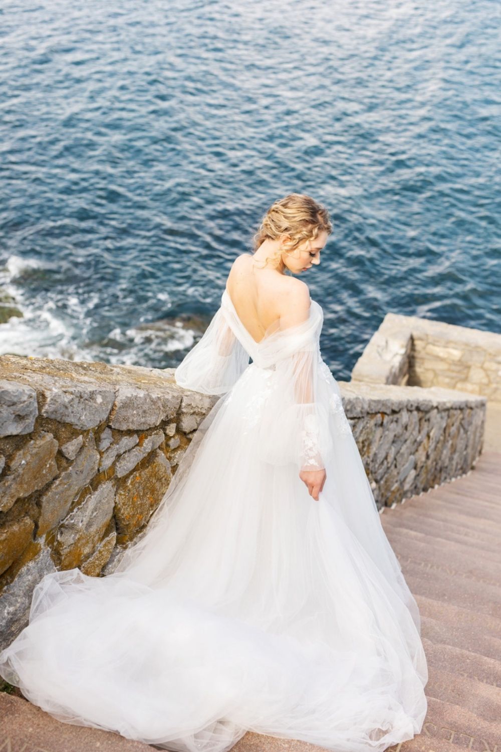 Bride on outdoor staircase in a white A-Line wedding gown